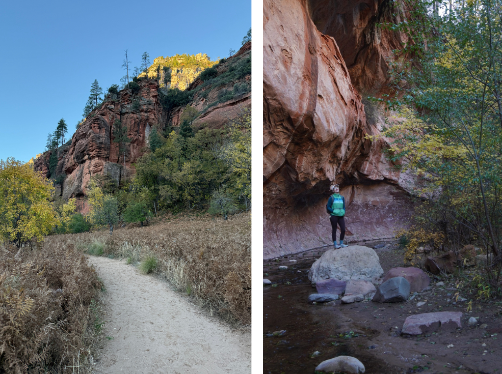 A dirt trail winds through a forest with towering red rock cliffs on the left, while a hiker in green stands at the base of a large rock formation.