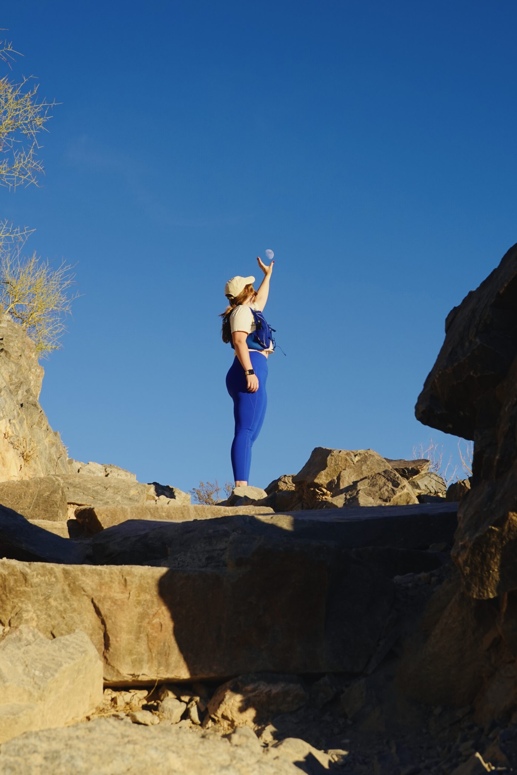 girl wearing a blue hiking outfit on top of a mountain