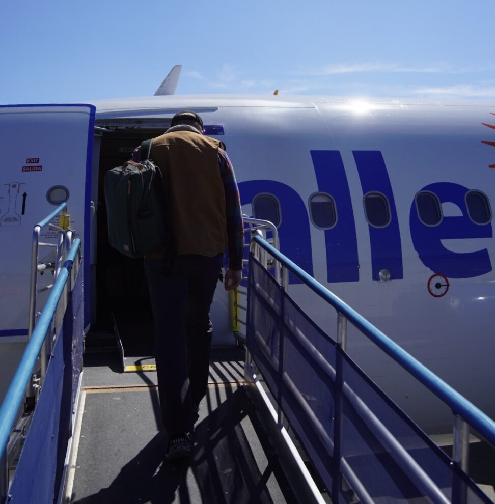 photo of a man with a carhart vest walking onto an allegiant air flight