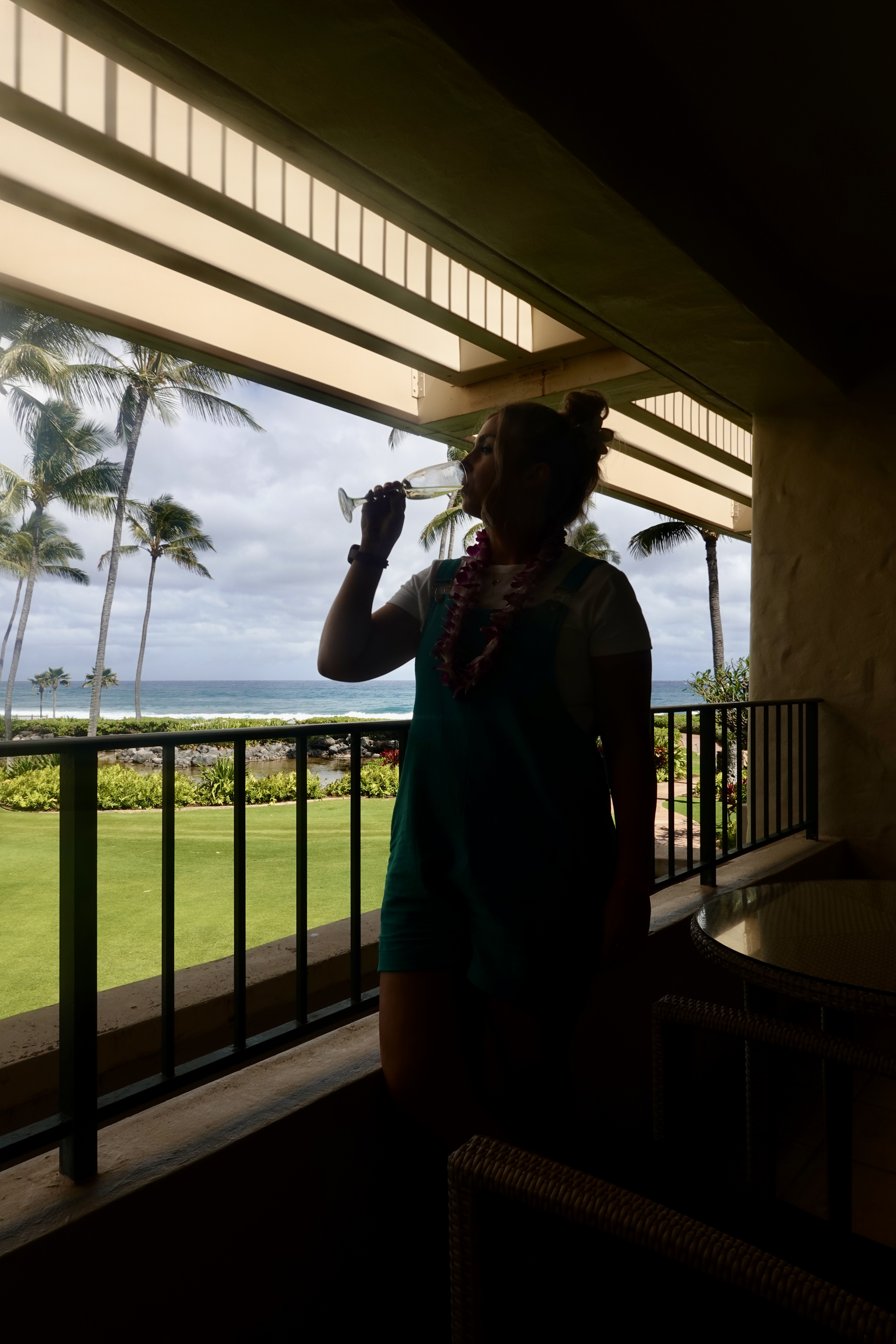 kauai hawaii hotel girl drinking champagne on a tropical hotel balcony