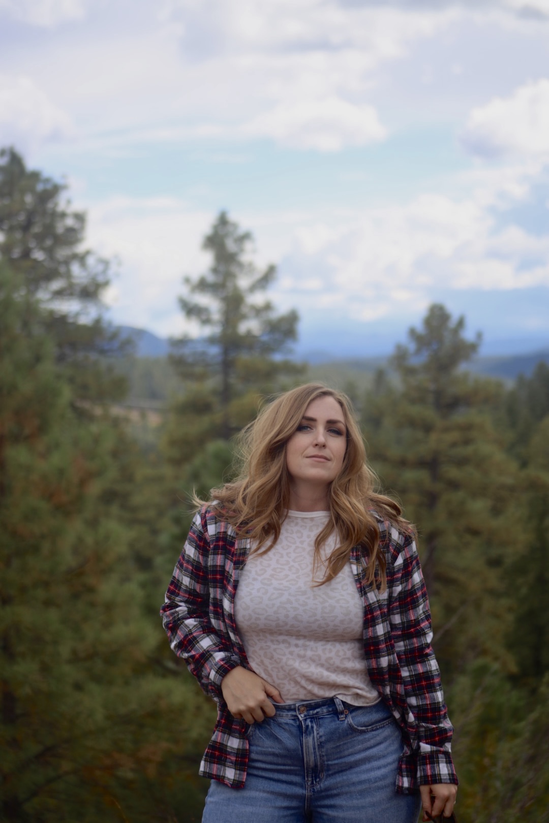 girl in plaid and tshirt in a foresty area in arizona