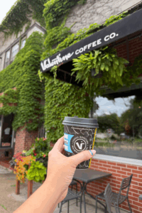 photo of a coffee cup in front of a sign that says valentine coffee roasters