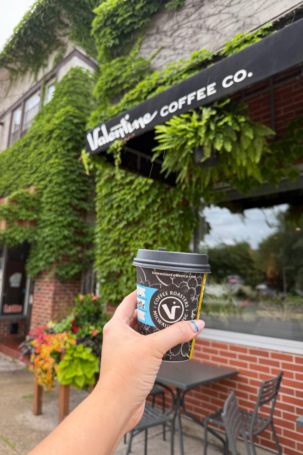 photo of a coffee cup in front of a sign that says valentine coffee roasters