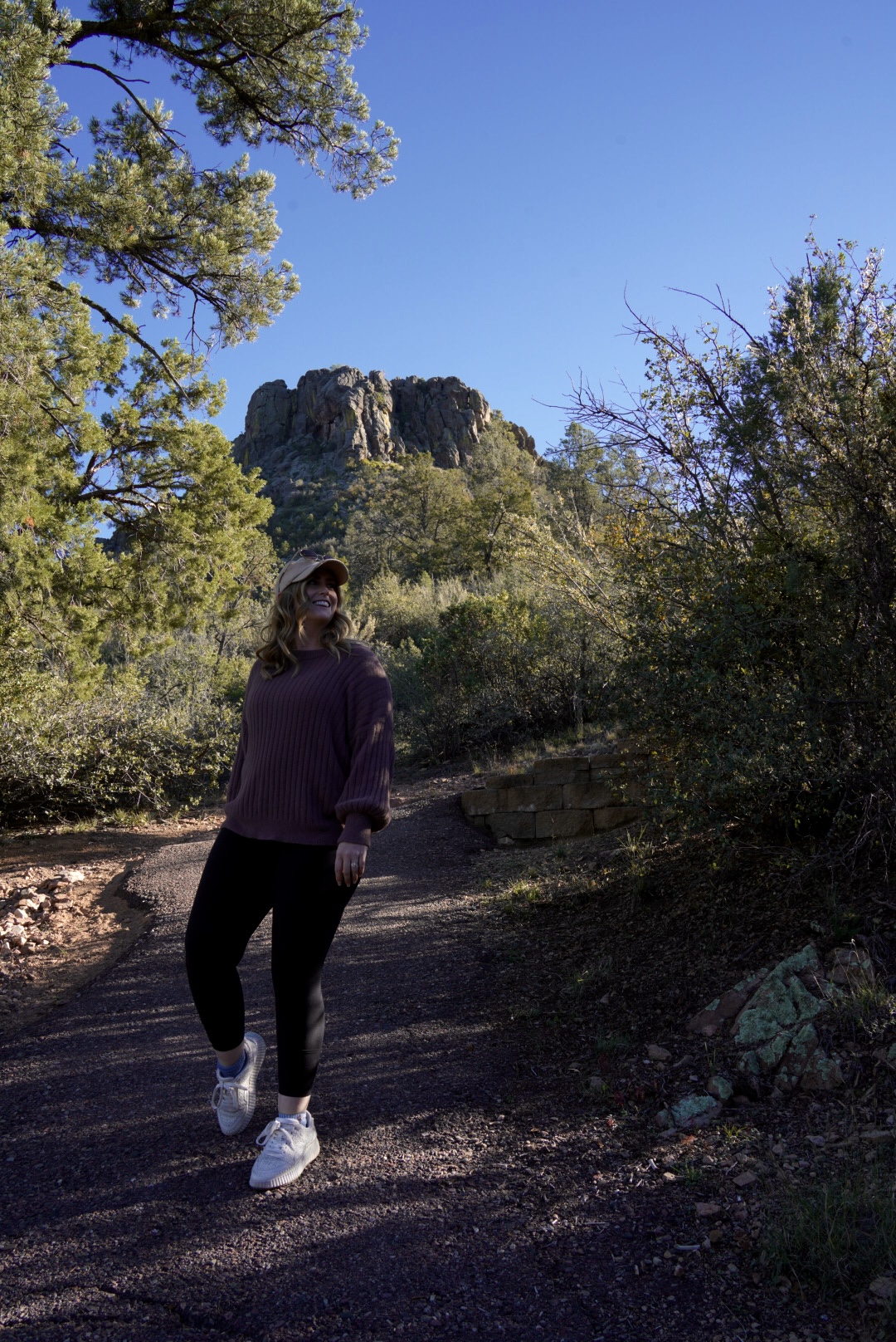 photo of a girl hiking in front of thumb butte