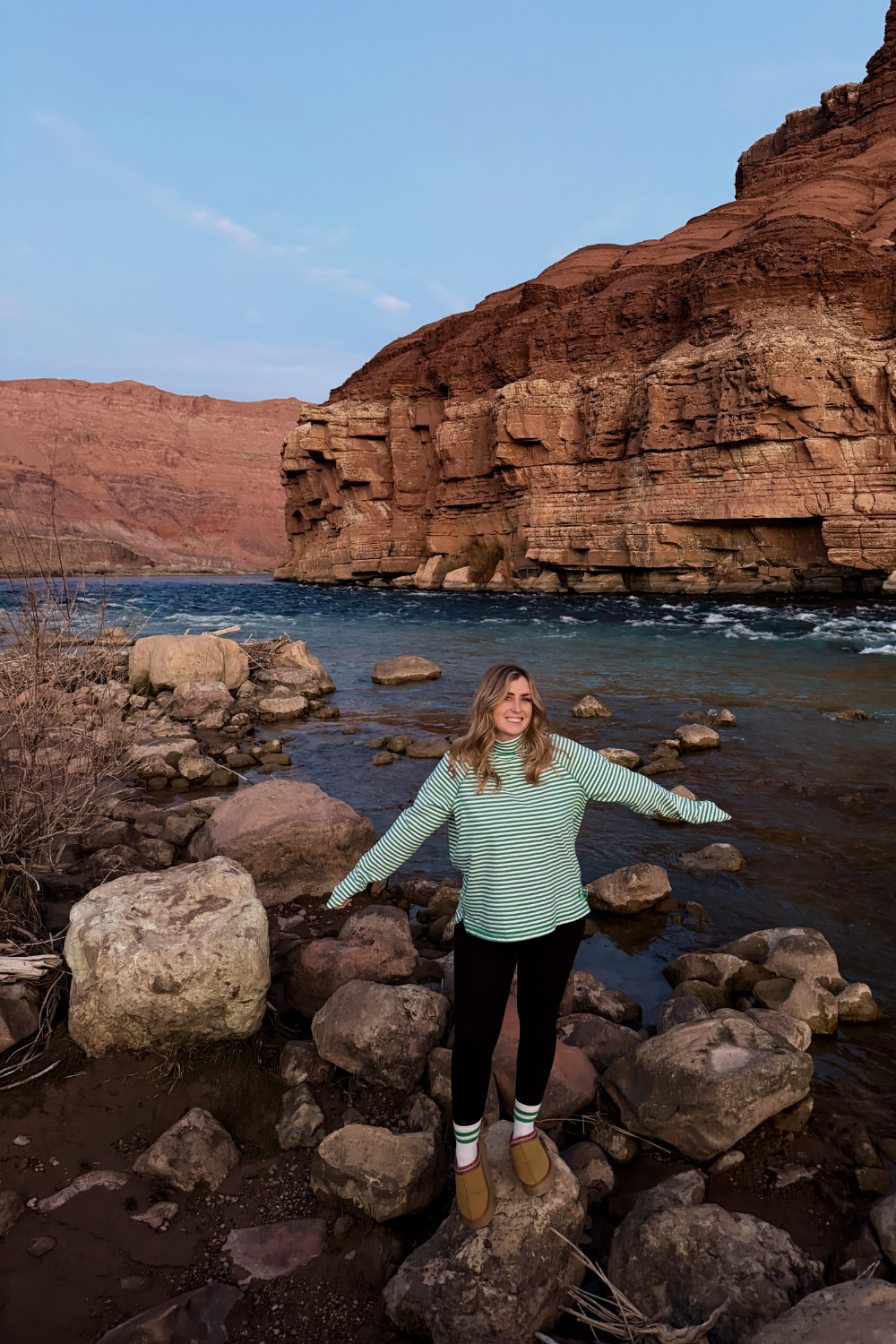 girl in a striped shirt standing at a desert beach