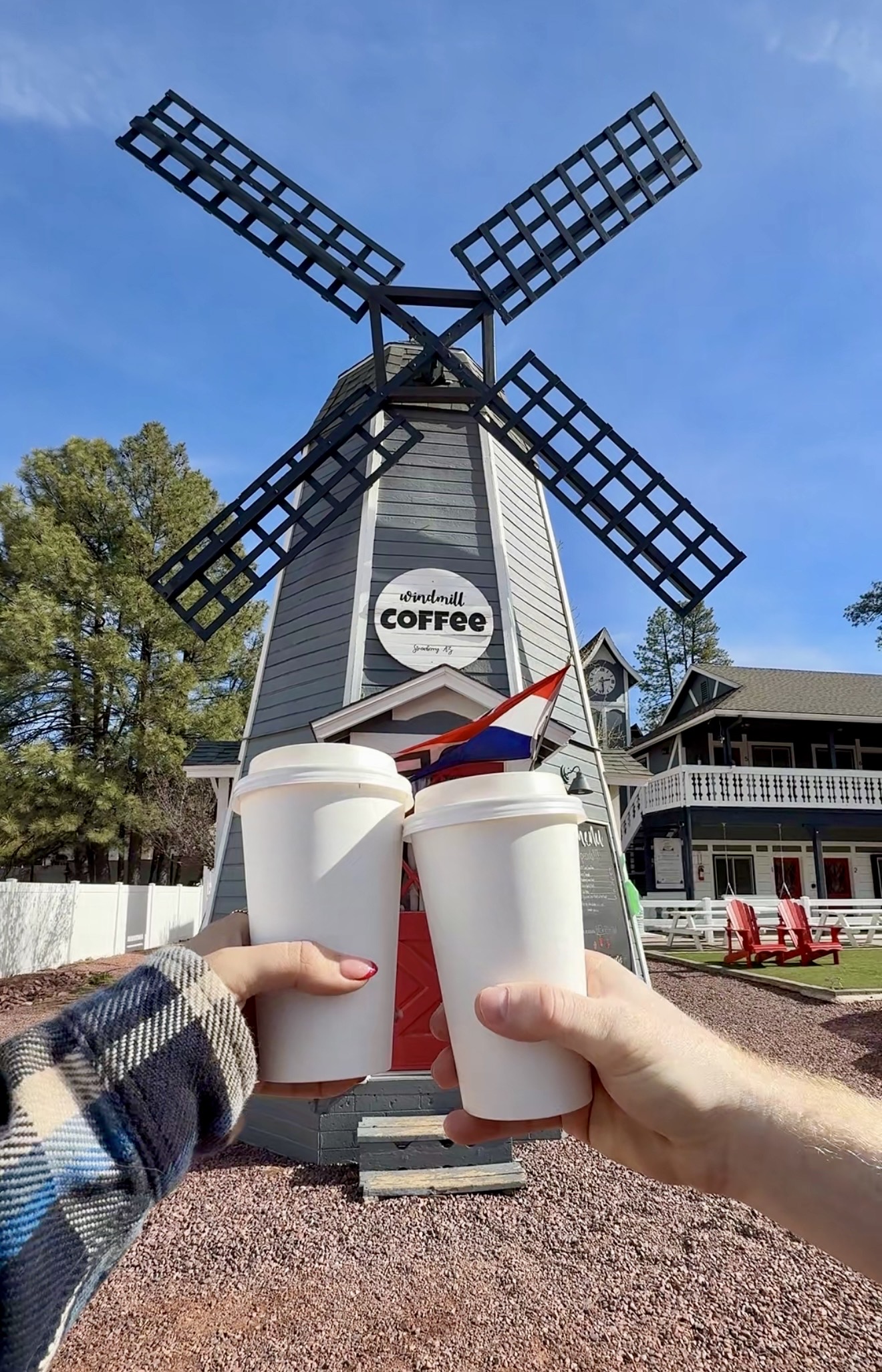 photo of two people cheers-ing coffee at a windmill coffee shop
