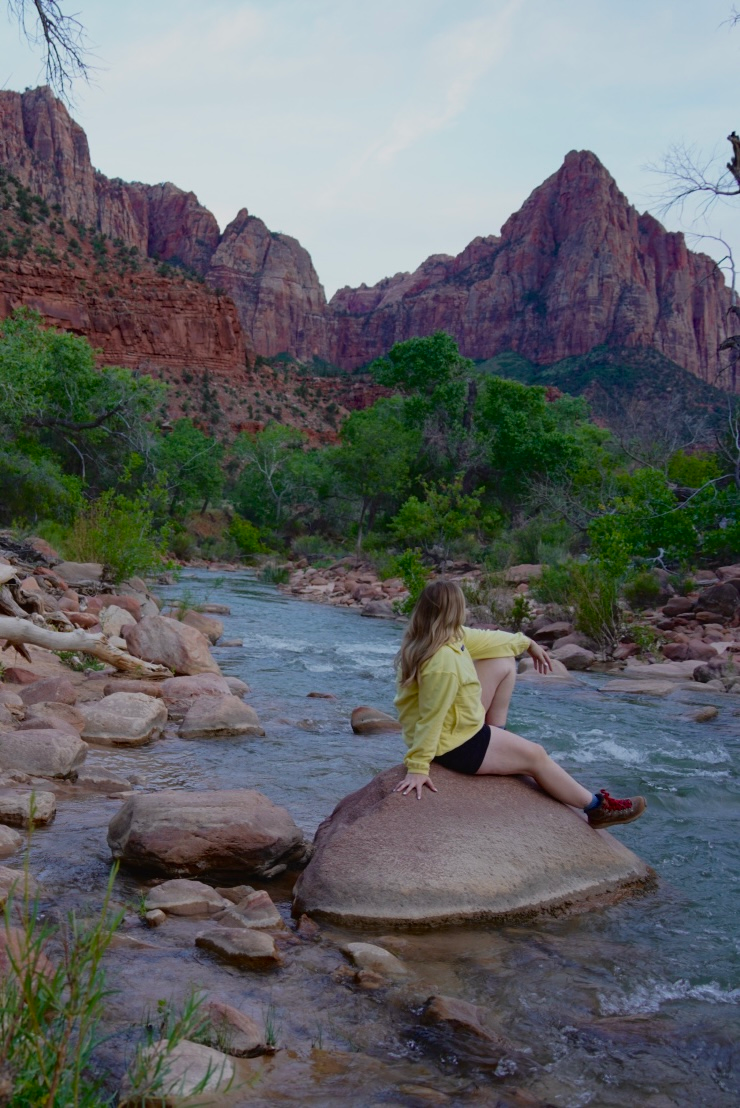 girl in yellow sitting on a rock in zion national park