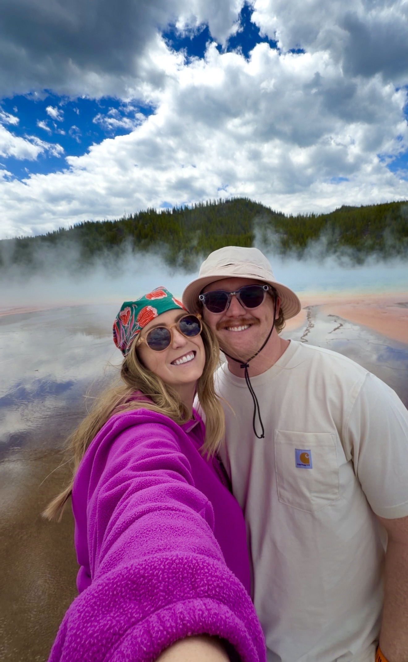 Danielle and Braiden at yellowstone two people smiling at grand prismatic spring at yellowstone