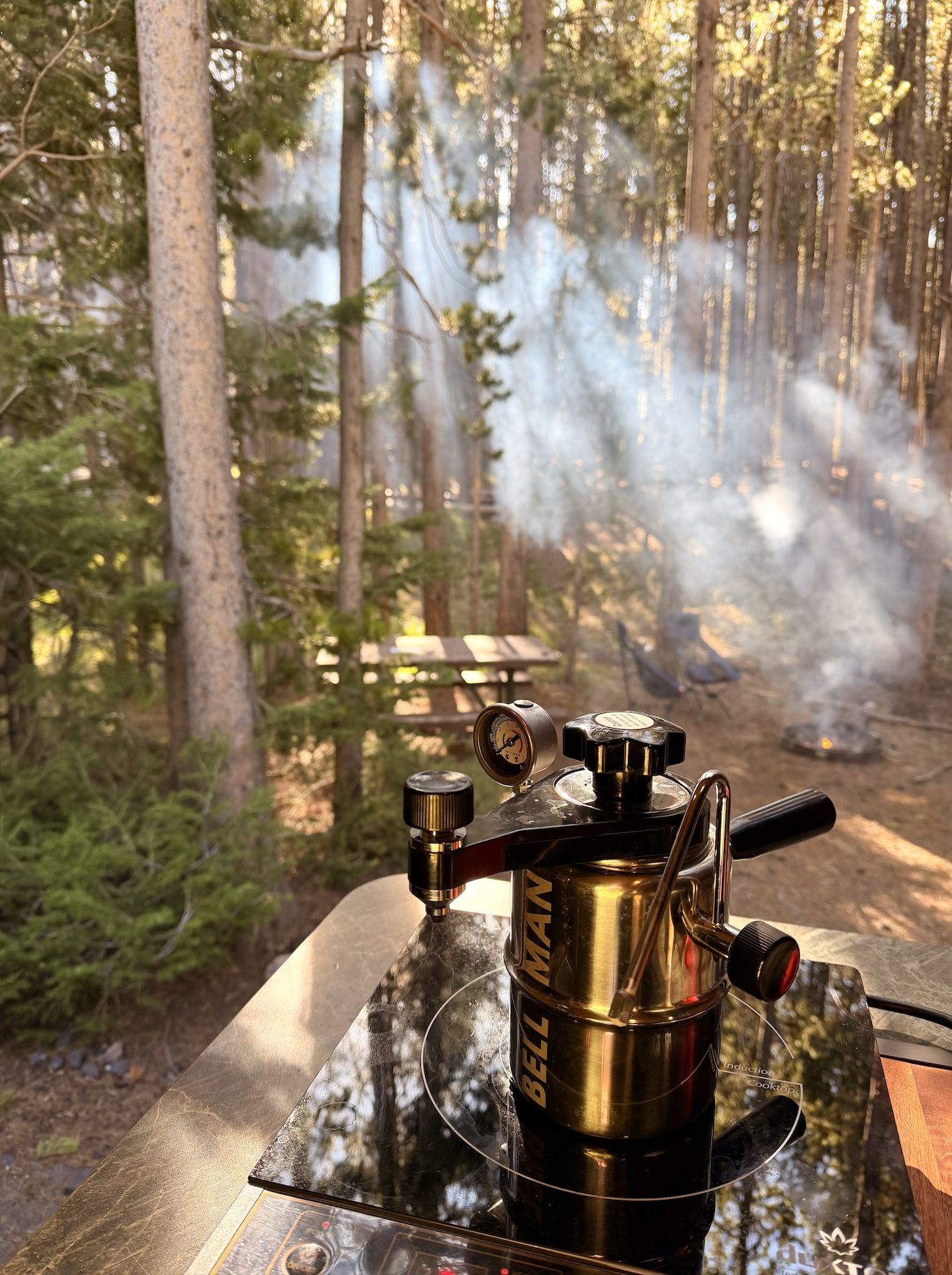 Bellman espresso maker on a camp kitchen counter at Canyon Campground inside Yellowstone National Park with morning campfire smoke filtering through the pine trees