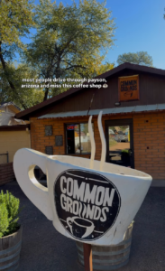 Exterior of Common Grounds Coffee in Payson, Arizona, featuring the iconic oversized coffee cup sign in front of the local coffee shop.