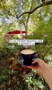 Latte served at The Indian Gardens Café in Sedona, Arizona, with the café's lush outdoor garden patio in the background.