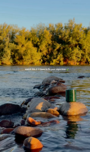 coffee cup on a rock by a river