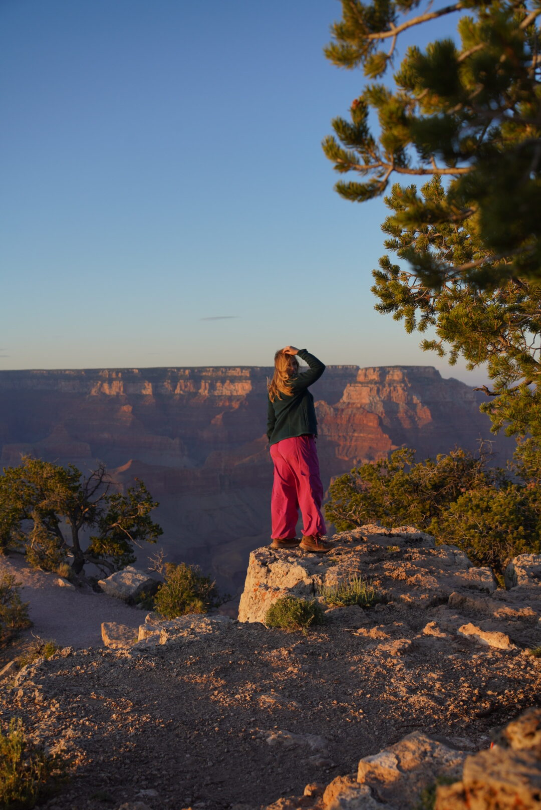 photo of a girl standing on the edge of the grand canyon