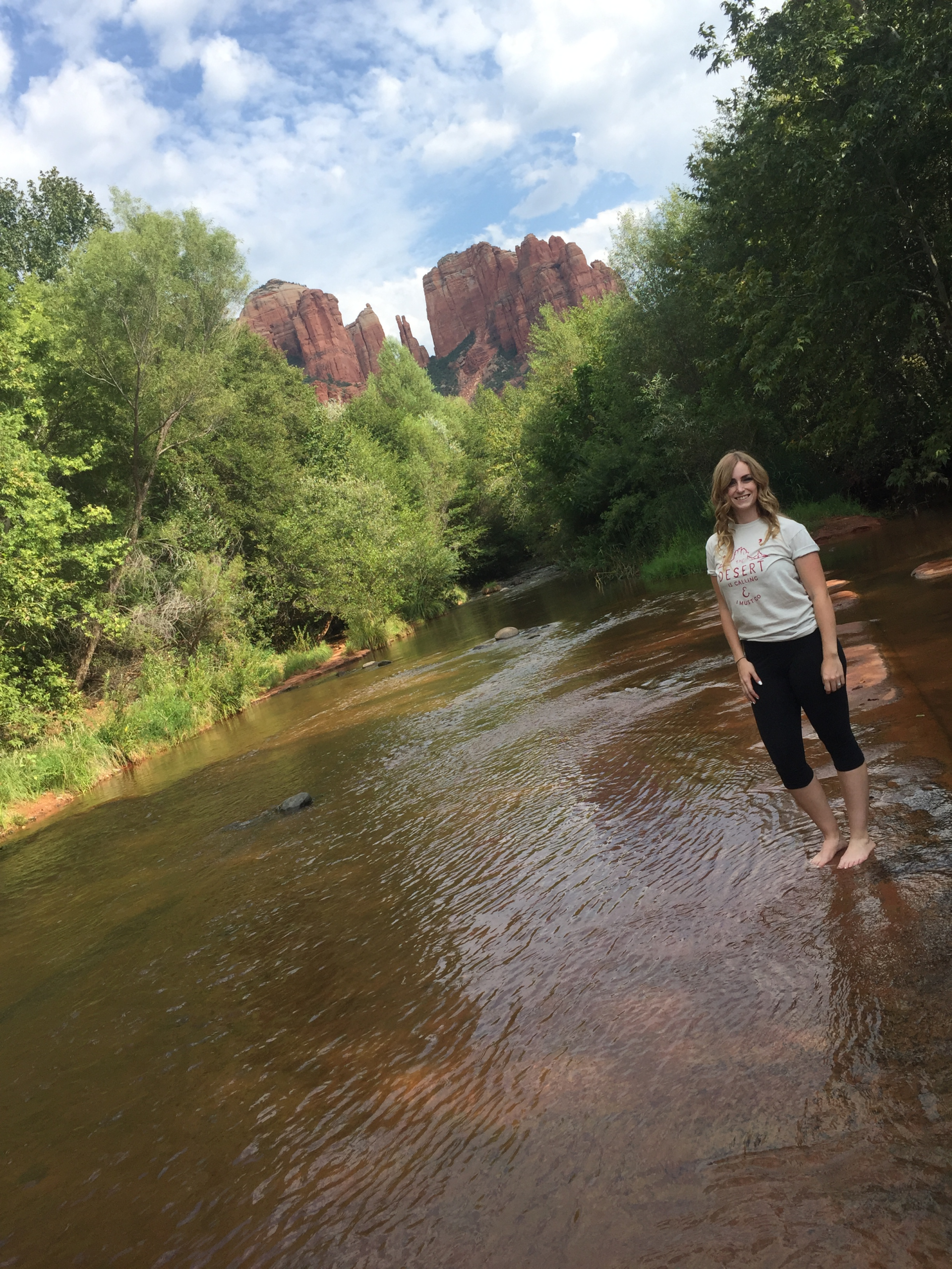 girl standing in the water in front of cathedral rock in sedona