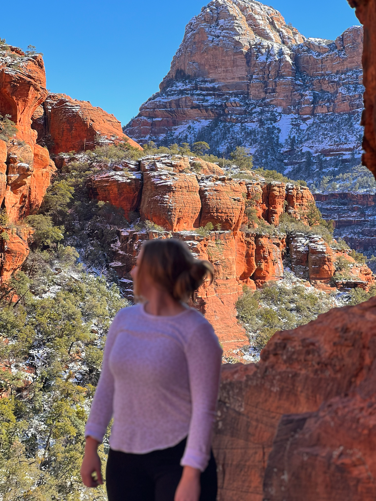 girl in white with backdrop of sedona in snow